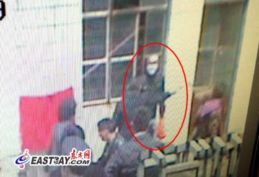 监控录像中，在众人追击下，该男子被围堵在一中学校门门口。