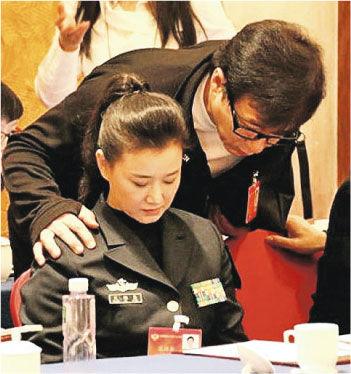 成龙从后“突袭”搭肩，低着头的宋祖英来不及反应。