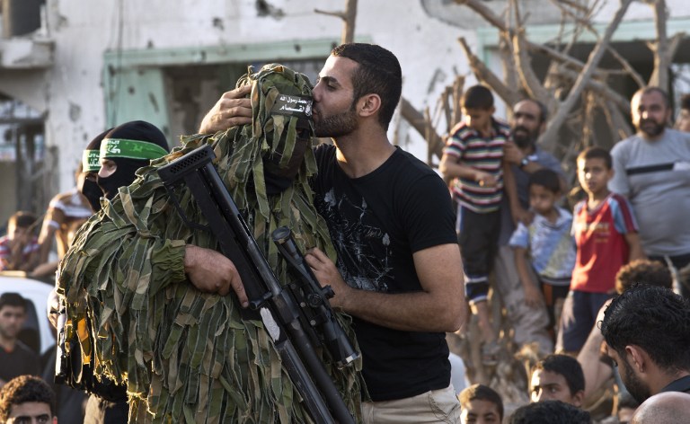 巴勒斯坦人亲吻哈马斯游行战士以色列与哈马斯均吹嘘获胜