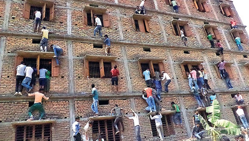 印度比哈尔邦高中升级考试 学生考试作弊家长爬楼当蜘蛛人递答案