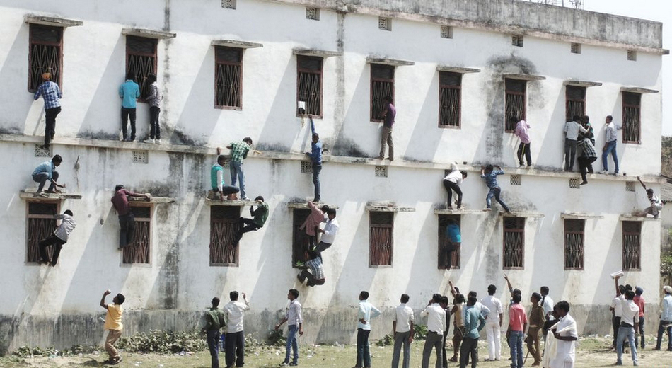 印度比哈尔邦高中升级考试 学生考试作弊家长爬楼当蜘蛛人递答案