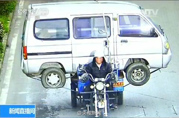 男子骑三轮摩托驮面包车上路 严重超载