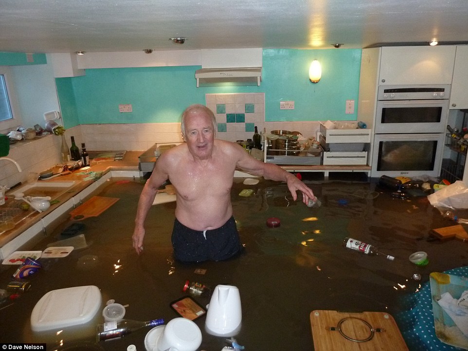 英国暴雨导致房屋被淹 72岁老人无惧在厨房里游泳