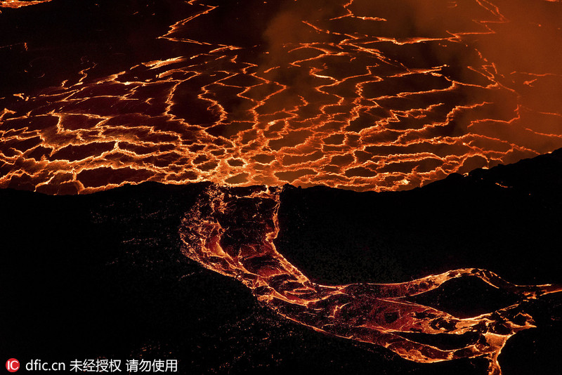 意地质学家活火山口拍岩浆流似红瀑布