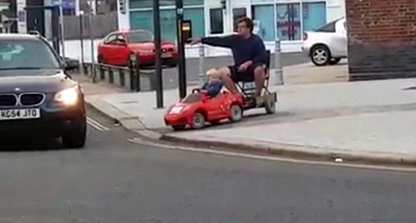 英国男童开玩具车“载”老爸回家
