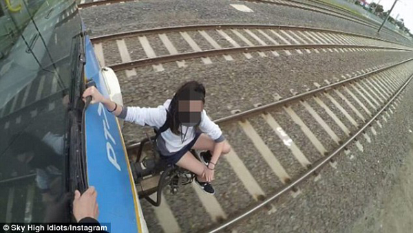 澳年轻人为博眼球在铁轨及车厢外做惊险动作