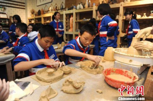 图为学生们在认真体验陶艺。 图为学生们在认真体验陶艺。