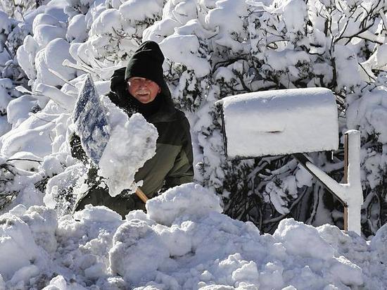 1月5日,美国马萨诸塞州锡楚埃特市,一名男子清理着道路上的积雪。(新华/美联)
