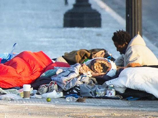 1月5日，美国首都华盛顿，一名无家可归者坐在地铁换气口取暖。(新华/法新)