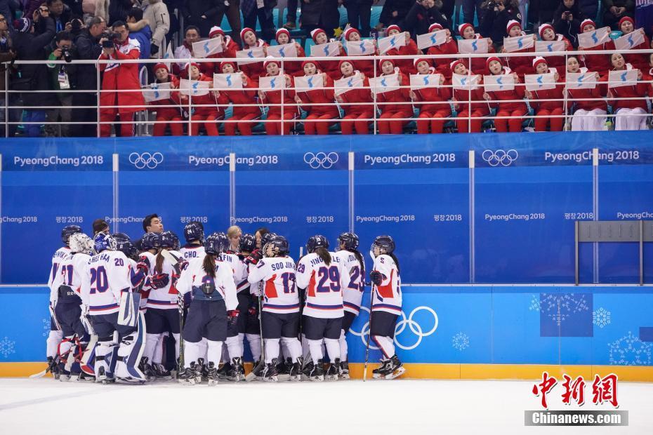 　　2月10日，2018平昌冬奥会女子冰球比赛开战，朝韩女子冰球联队（白色球衣）首秀对阵瑞士队，最终朝韩联队以0比8败于瑞士队。赛后朝韩联队聚在一起，台上来自的朝鲜啦啦队则手持半岛旗帜为她们加油打气。中新社记者 崔楠 摄