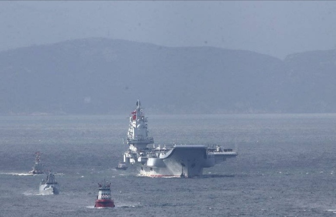【环球网军事综合报道】有照片显示中国海军辽宁号航母在航行时，在右舷前方有一艘056型轻型护卫舰航行的情景。辽宁号是目前中国海军现役最大的水面战舰，而056型则是中国一款轻型护卫舰，仅有1400吨，两艘军舰组成了“最萌身高差”。