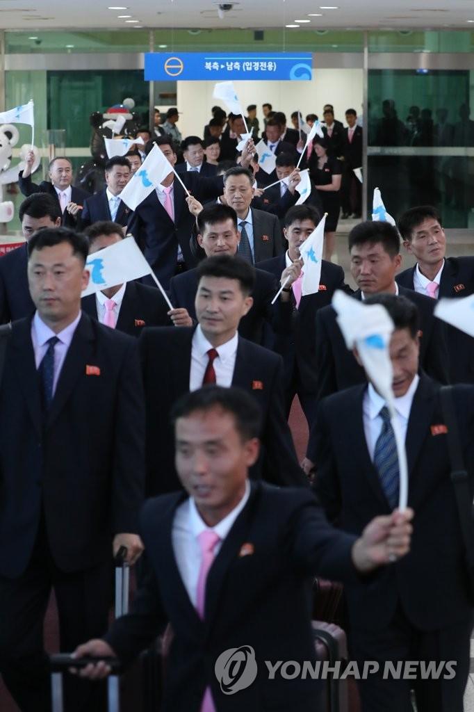 朝鲜工人足球队抵达韩国:举统一旗 戴领袖徽章