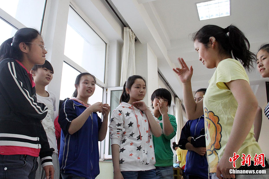 图为聋哑学生在练舞间隙手语交流心得.韦亮 摄
