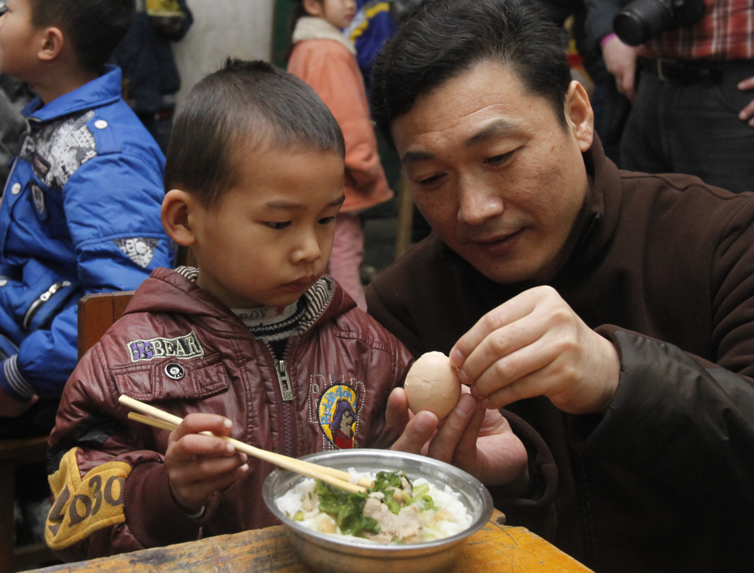 志愿者给学生剥鸡蛋吃 