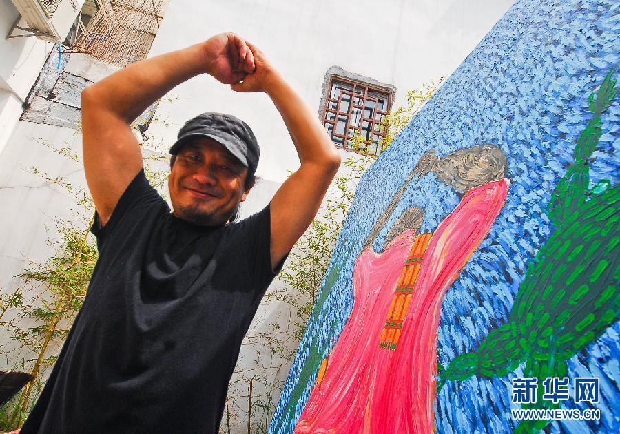 9月21日,画家陆永忠在其大地系列作品之《谢天谢地》前摆出感谢的手势