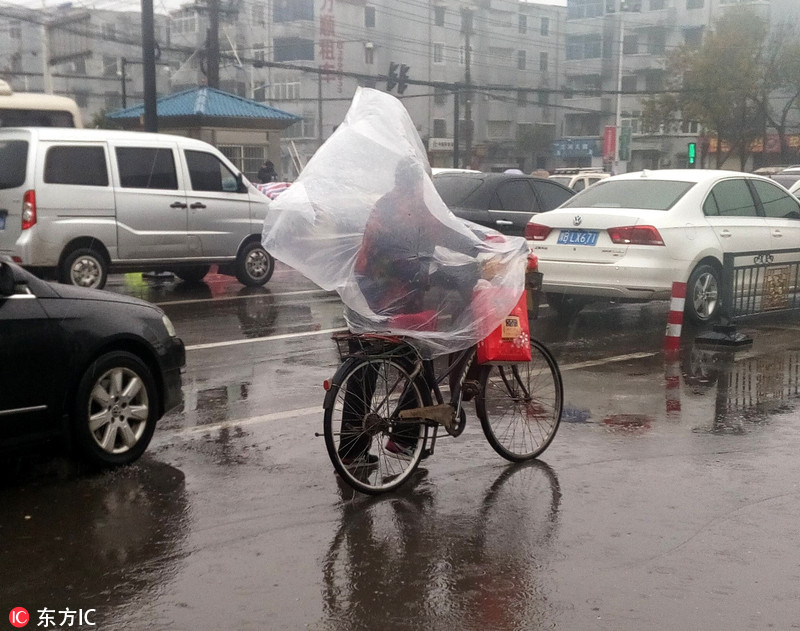 开封街头现骑车"牛人" 大塑料充当雨衣