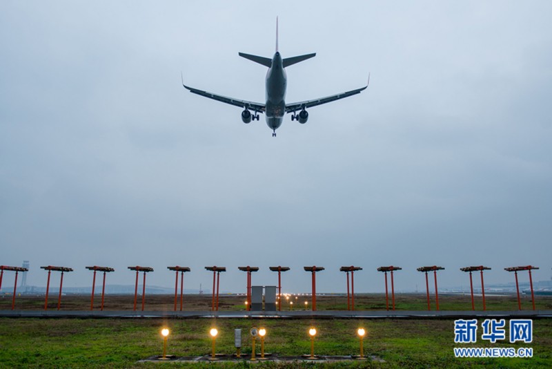 一架飞机借助助航灯光系统,降落至重庆江北机场.新华网 李相博摄