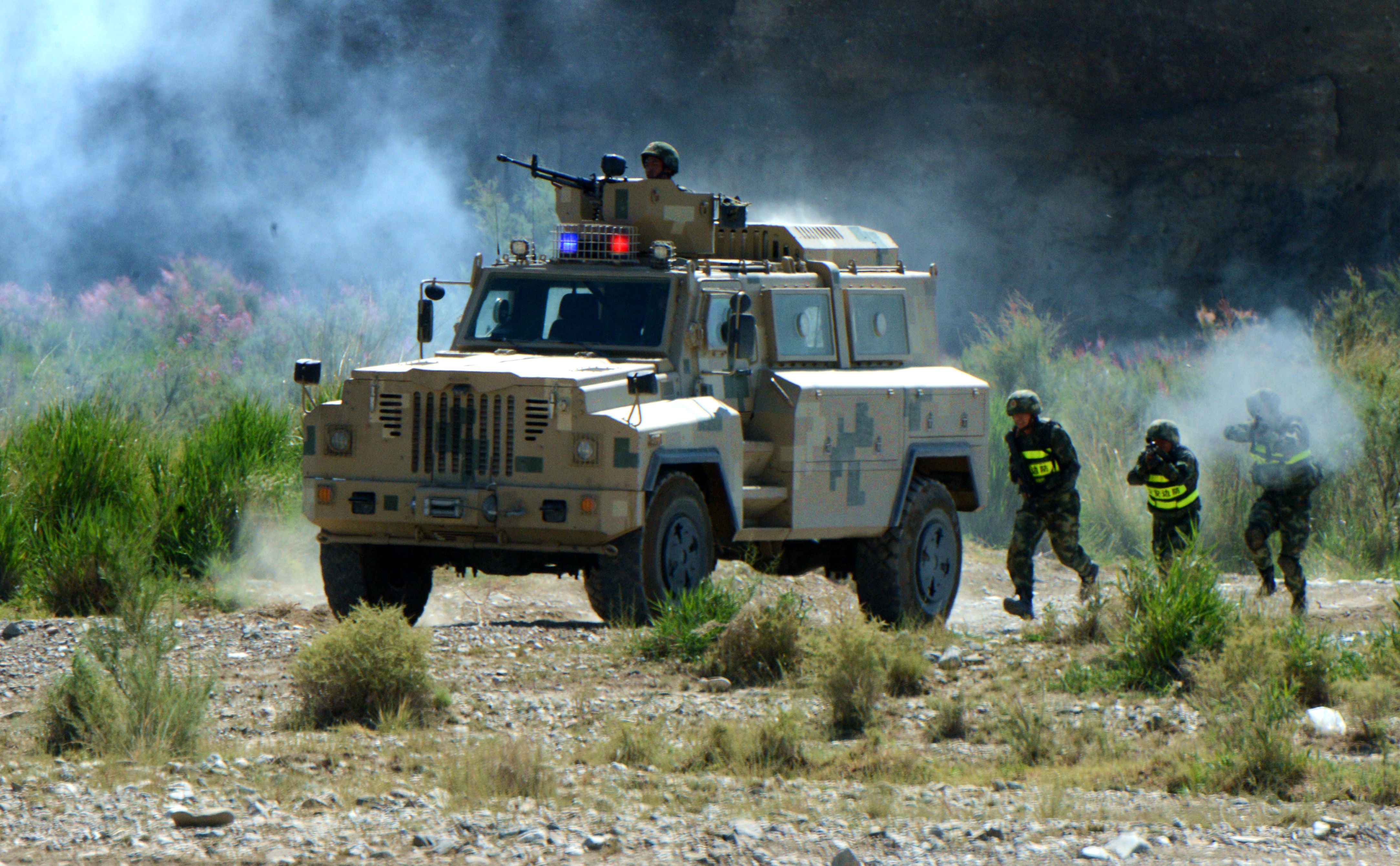 图为边防官兵正在协同装甲车实施进攻(王小雪摄)