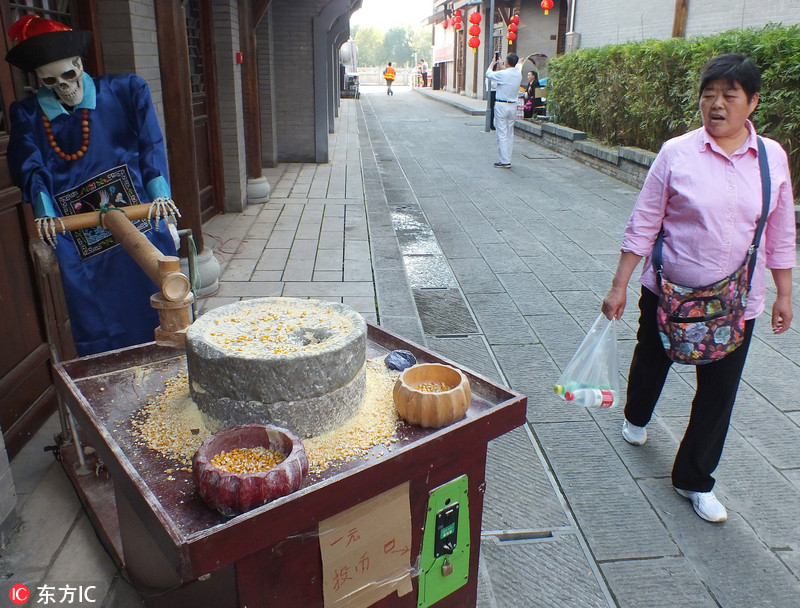 湖北宜昌龙泉古镇两小鬼推磨 游客看稀奇